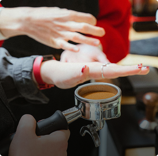 barista's hands preparing a shot of espresso in the portafilter