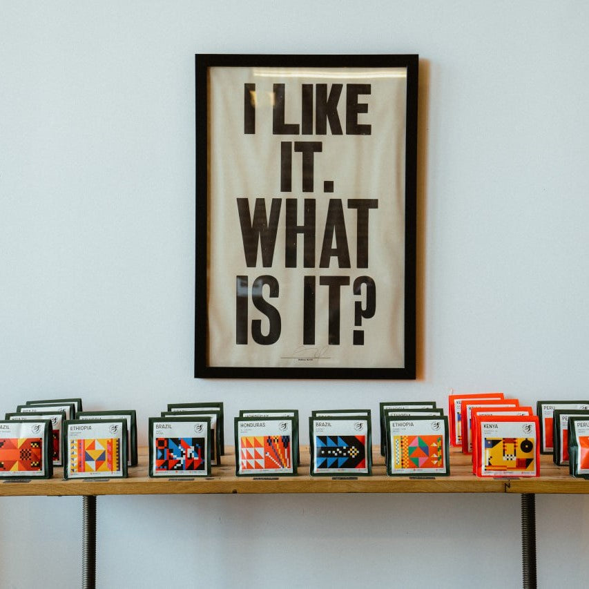 a picture on a wall above multiple bags of ethica specialty coffee